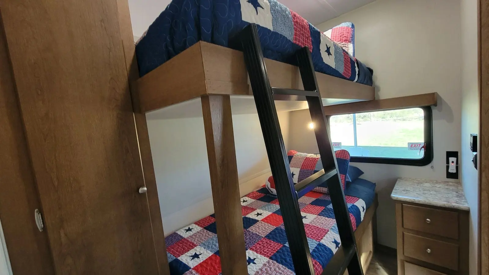 A small secondary room with bunk beds, both made up with Texas patterned quilts.
