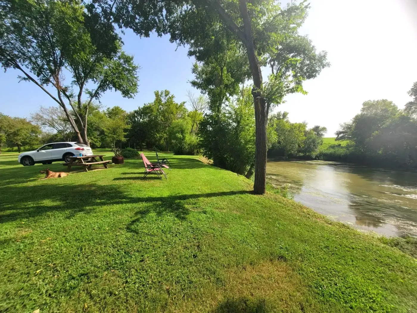 Image of a car parked by the riverside picnic table.