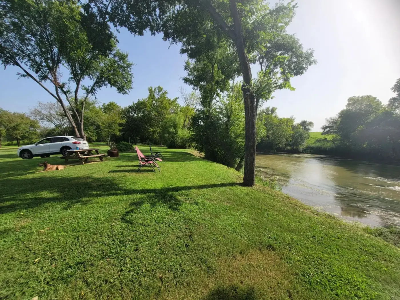 Image of a car parked by the riverside picnic table.