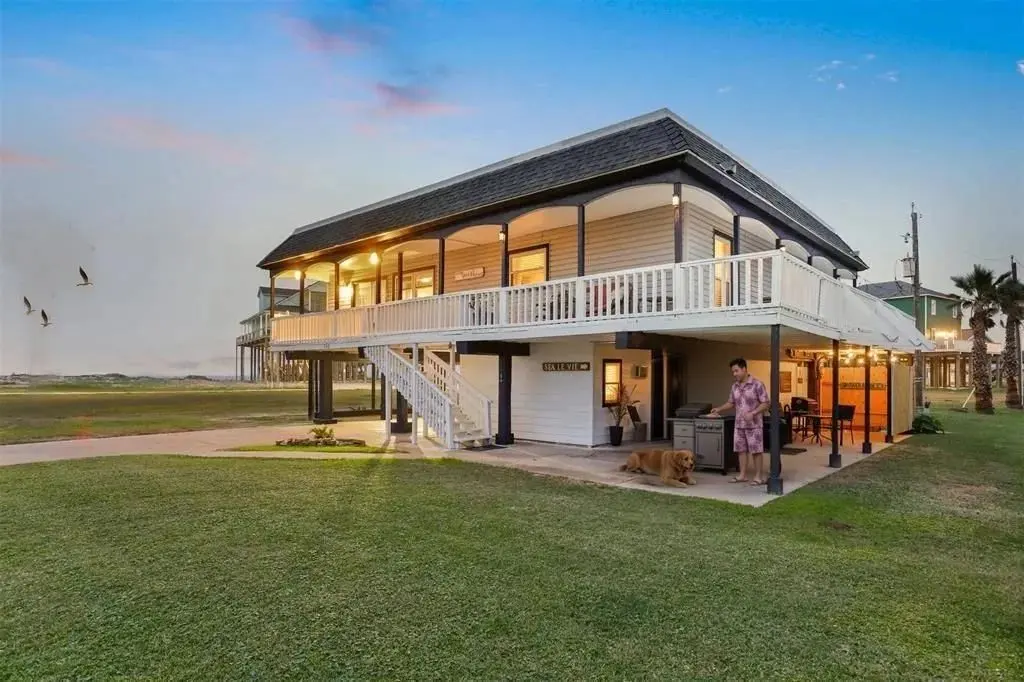 Image of the front of Sea La Vie with a man and his dog by the propane grill.